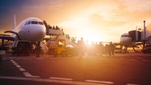 Travellers boarding a plane at sunset