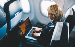 Traveller using laptop in board