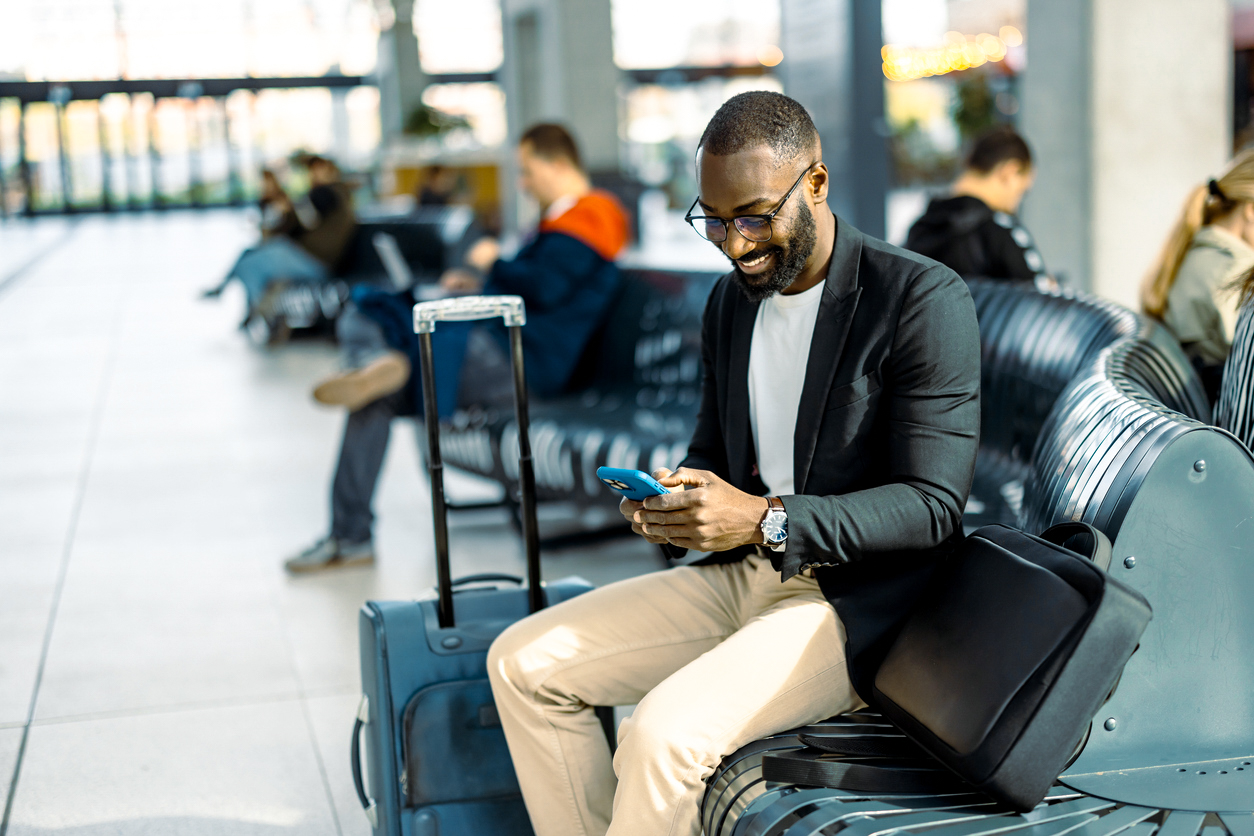 Traveller using his phone in airport