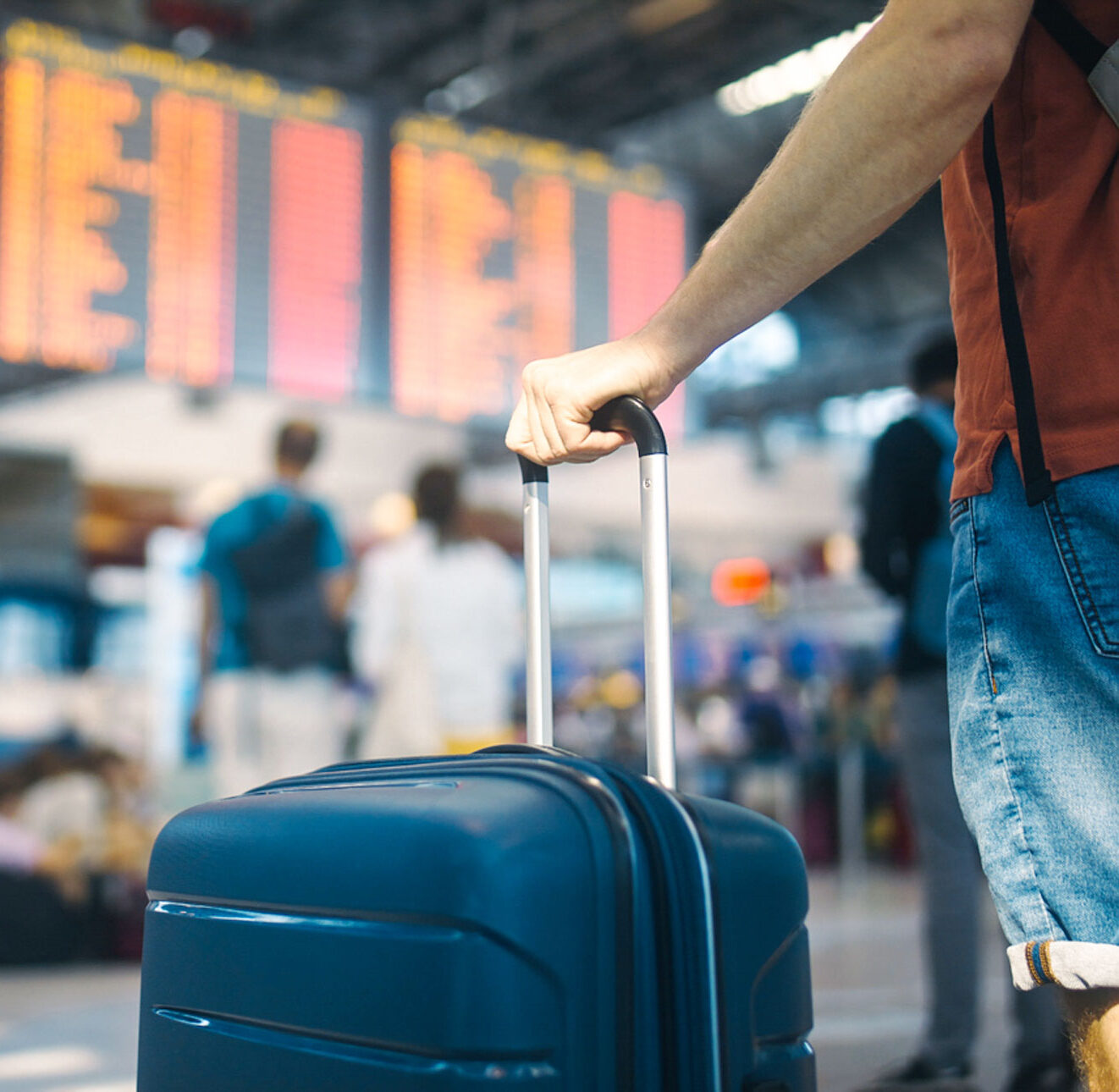 Traveller consulting a digital departure board at airport