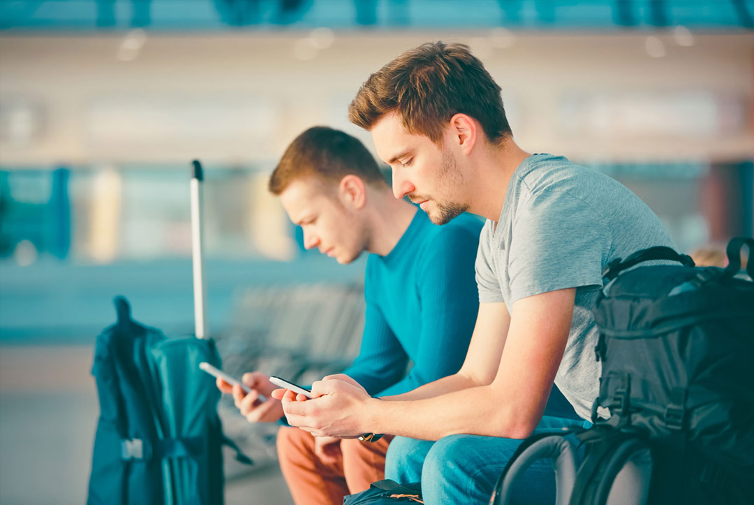 Travellers checking their mobile phones
